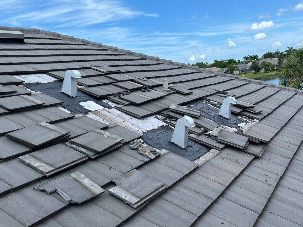 slate gray tile roof with panels missing